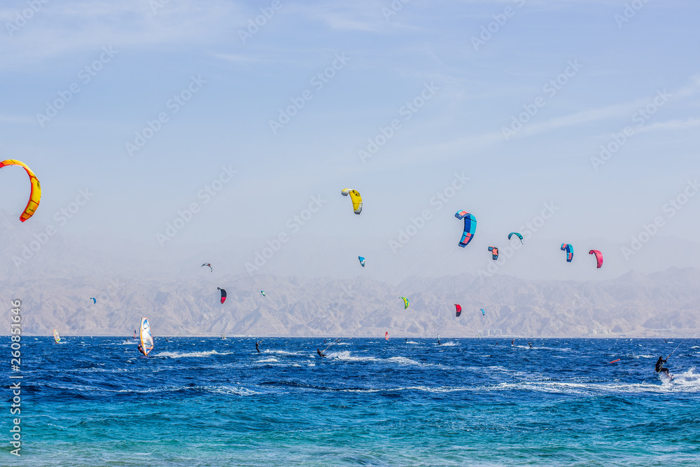 summer vacation season concept scenic landscape photography of Red sea nature view with wind surfers on a water surface and sails in the sky