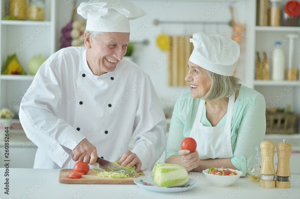 Portrait of couple of smiling senior chefs at kitchen Portrait of couple of smiling senior chefs at kitchen