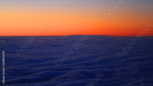 Sunrise from the airplane, high above clouds
