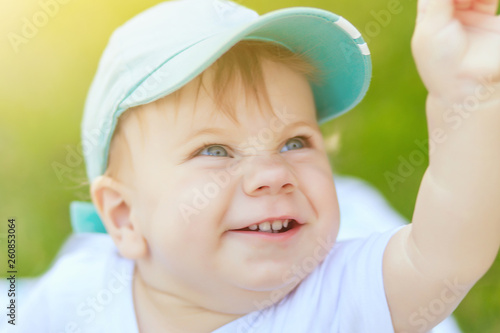 portrait of a young boy blond with blue eyes who smiles in the summer in sunny weather