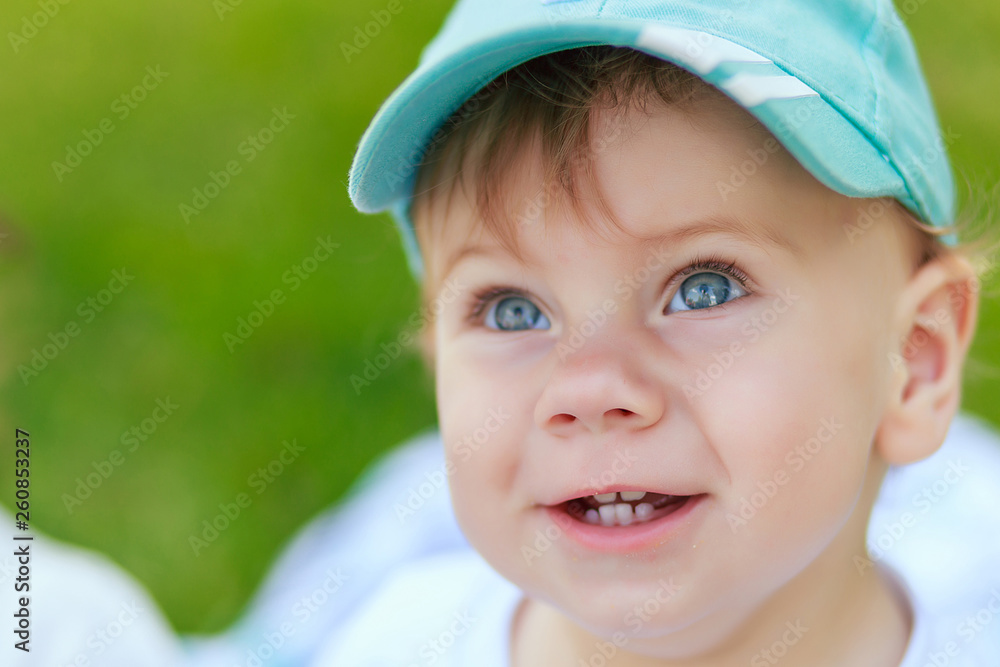 portrait of a young boy blond with blue eyes who smiles in the summer in sunny weather portrait of a young boy blond with blue eyes who smiles in the summer in sunny weather