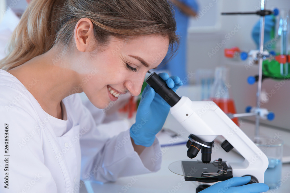 Medical student working with microscope in modern scientific laboratory Medical student working with microscope in modern scientific laboratory