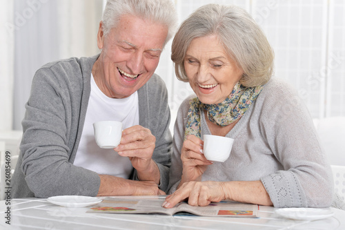 Portrait of mature couple with magazine drinking tea 