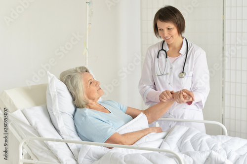 Принти на полотні Portrait of smiling senior woman in hospital with caring doctor
