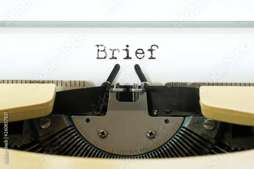 Billede på lærred Brief word typed on a yellow vintage typewritter