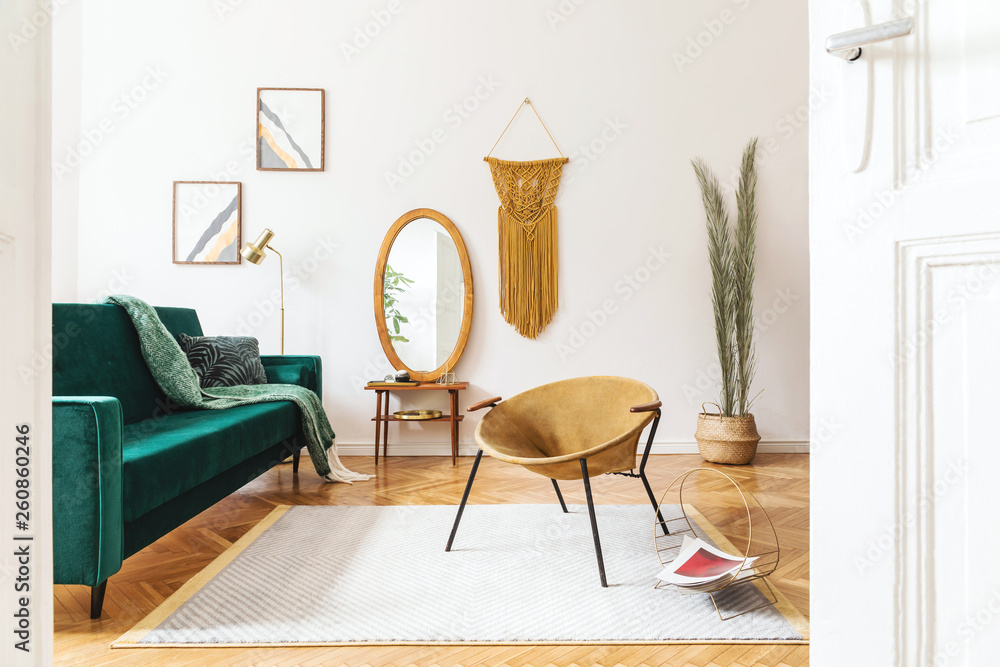 Φωτογραφία Stylish and elegant interior of living room with design gold armchair, velvet sofa, lamp, poster frames
