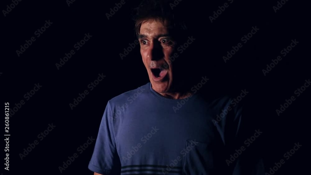 Scared man with burglar coming out of nowhere. Black background Scared man with burglar coming out of nowhere. Black background