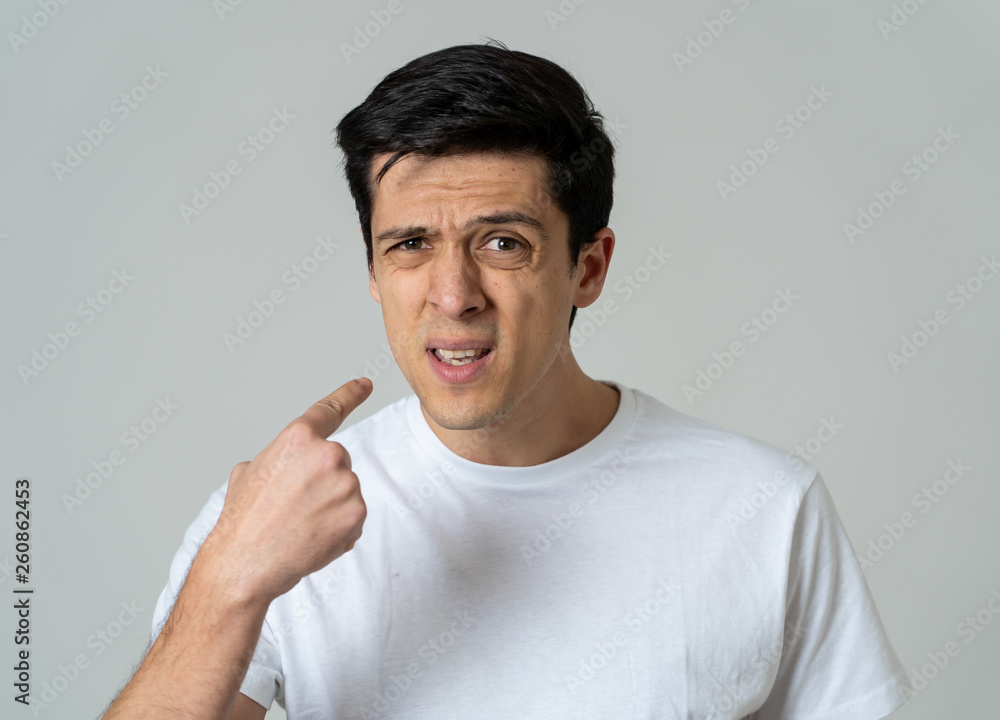 Portrait of a handsome young man with angry face looking disgusted. Human expressions and emotions Portrait of a handsome young man with angry face looking disgusted. Human expressions and emotions
