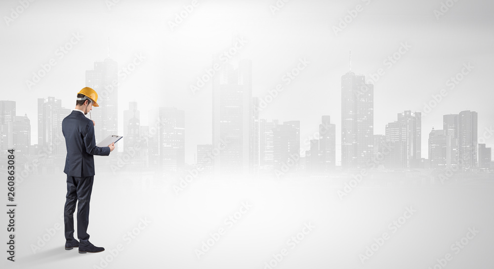 Young supervisor architect standing and looking at a big city panorama
Young supervisor architect standing and looking at a big city panorama