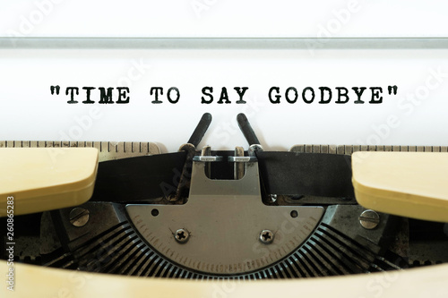Time to say goodbye word typed on a yellow vintage typewritter. Business concept.