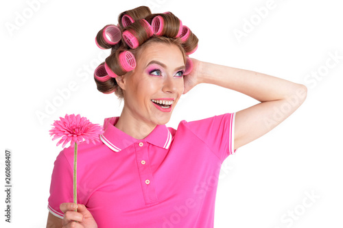 Portrait of young woman in hair curlers holding pink flower