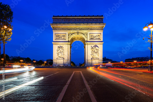 Paris street at night with the Arc de Triomphe in Paris, France. © ake1150