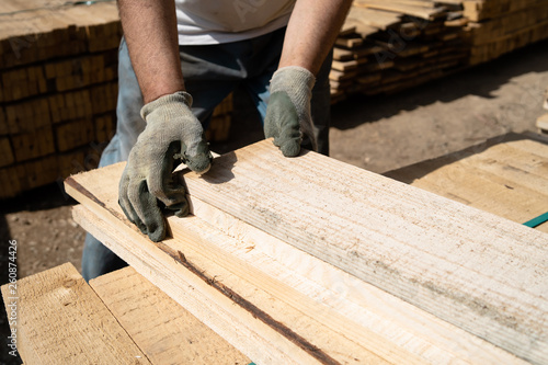 Close up on the worker holding building material planks loading at the warehouse for the construction site