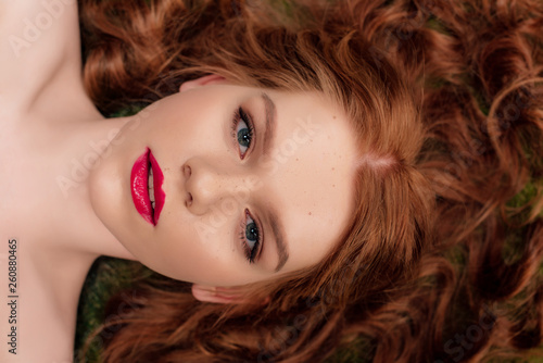 top view of beautiful young redhead woman with red lips looking at camera