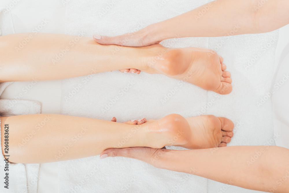 partial view of masseur doing foot massage to adult woman in spa partial view of masseur doing foot massage to adult woman in spa
