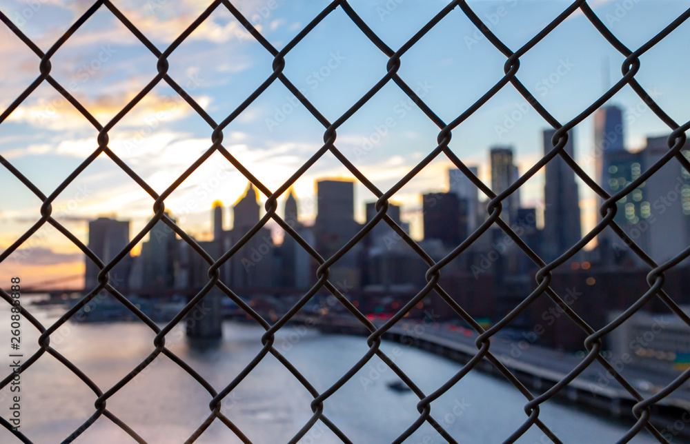 New York City skyline seen through a chainlink fence in Manhattan New York City skyline seen through a chainlink fence in Manhattan