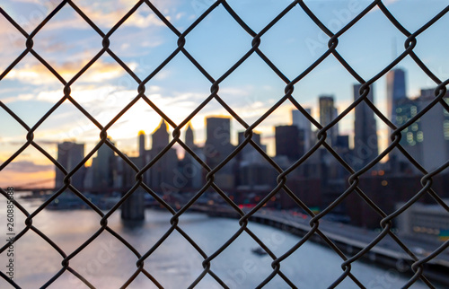 New York City skyline seen through a chainlink fence in Manhattan