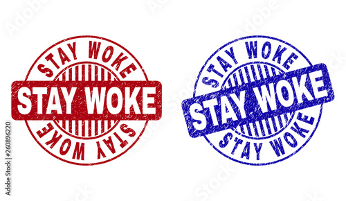 Grunge STAY WOKE round stamp seals isolated on a white background. Round seals with grunge texture in red and blue colors. Vector rubber imitation of STAY WOKE label inside circle form with stripes.