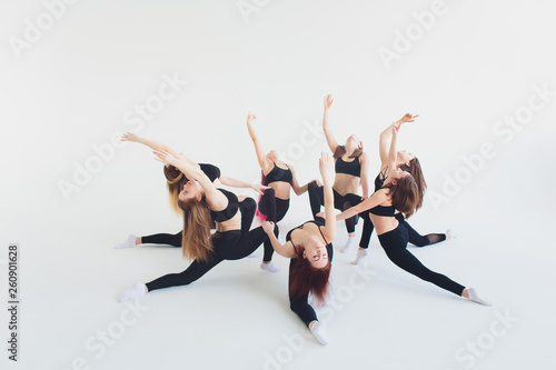 Fitness, stretching practice, group of two attractive happy smiling fit mature women working out in sports club, doing Extended Side Angle posture, utthita parshvakonasana pose in class, full length. photo