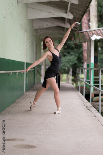 Happy redhead smiling girl dancing in a green park on Brazil in a summer day