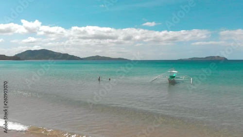 Couple in the turquoise ocean next to boat