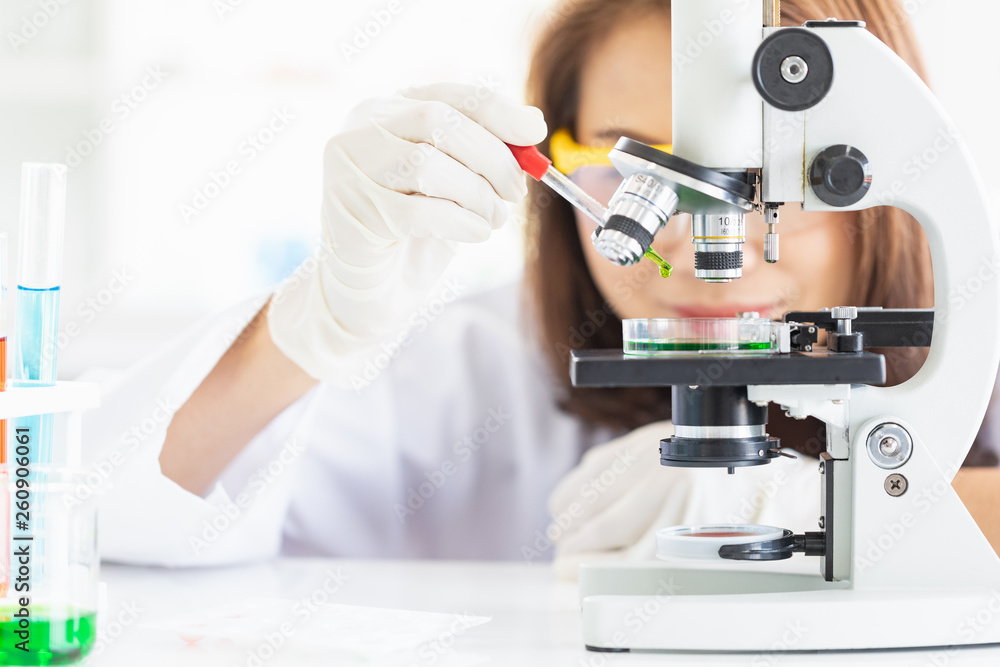 Scientist dropping liquid to petri dish.. Scientist dropping liquid to petri dish..