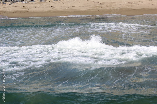 Waves splashing onto the beach , they roll in every few seconds and splash around.