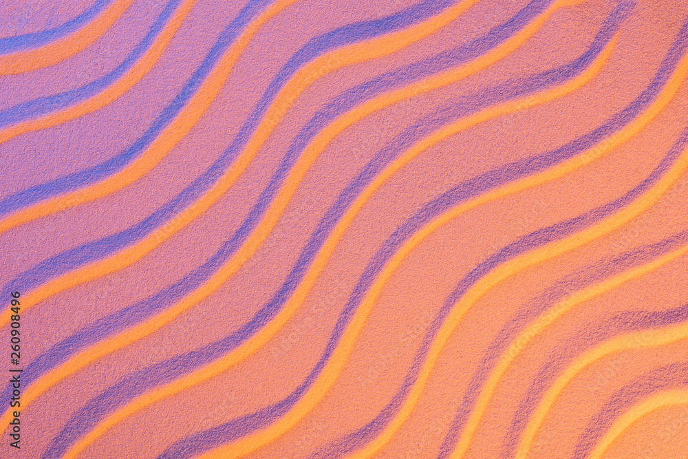top view of textured sand with smooth waves and neon pink color filter