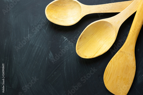Wooden spoons with black textured background