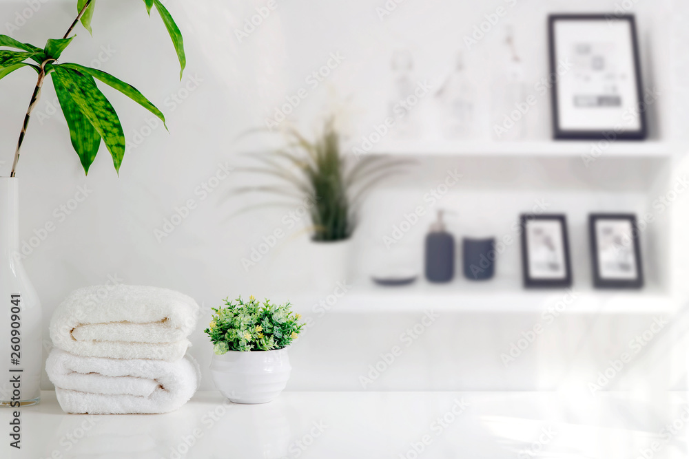 Mockup bath towels on wooden table in white room with copy space.