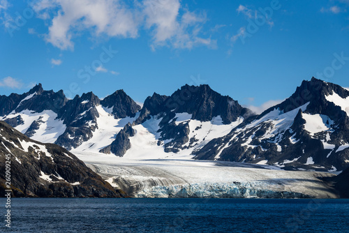 Large glacier surrounded by snowy mountains feeding into the sea at Drygalski Fjord, South Georgia © knelson20