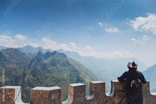 Traveler woman standing on the top of mountain at stopover for sightseeing during the tourist route of North Vietnam.Beautiful landscape for adventure travel.
