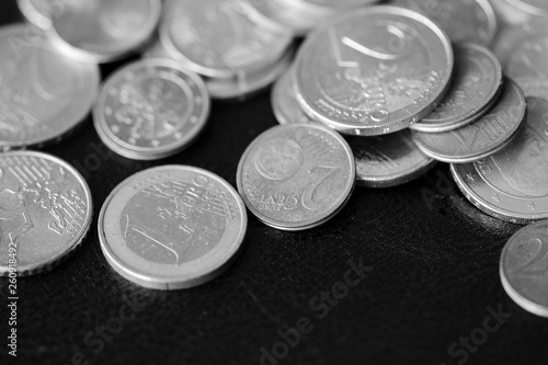 Euro coins scattered on a dark background close up. Black and white