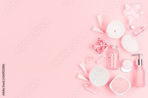 Cosmetics for salon aromatherapy, massage or bathroom - bath salt, cream, essential oil, soap, bowls, bottles, jewelry on elegance pink background.