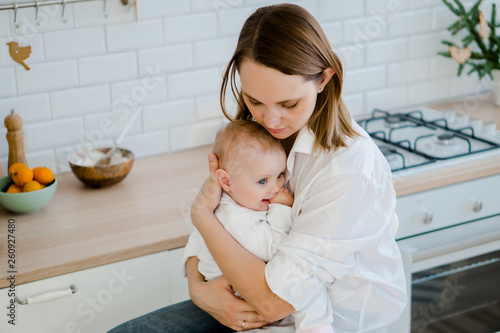 mom holding baby in the kitchen