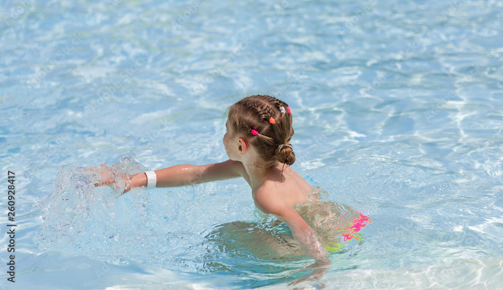 Little girl playing in transparent water