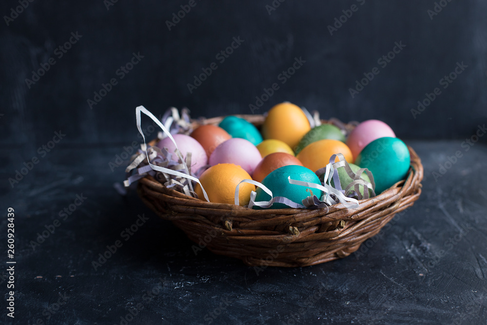 Colorful Easter eggs in basket on black wooden background with copy space. Colorful Easter eggs in basket on black wooden background with copy space.