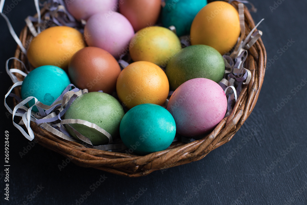 Colorful Easter eggs in basket on black wooden background with copy space. Colorful Easter eggs in basket on black wooden background with copy space.
