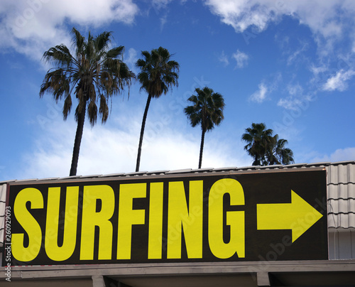 aged and worn surfing sign with palm trees