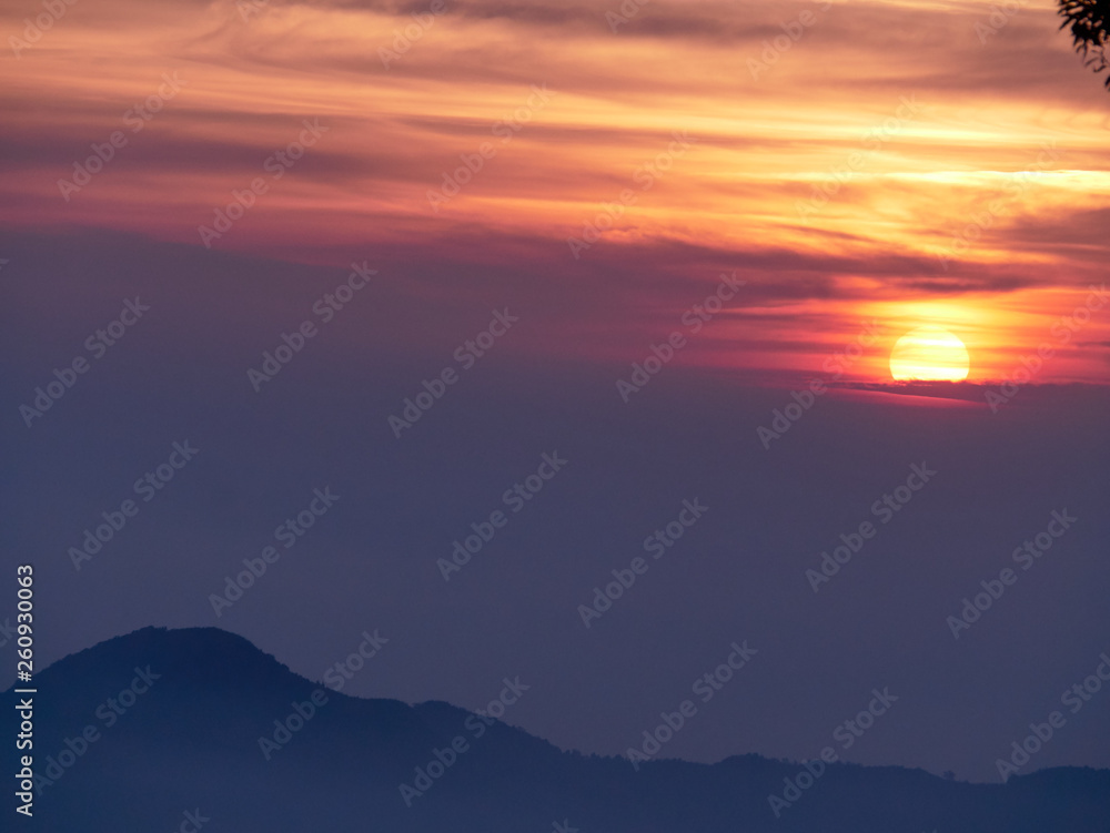 Sun set in Taiwans mountain region - Alishan mountain sun set in warm pastel colors with fog between mountain ranges Sun set in Taiwans mountain region - Alishan mountain sun set in warm pastel colors with fog between mountain ranges