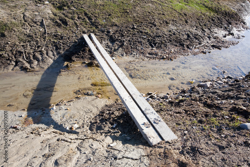 Photos two planks crossing over a ditch