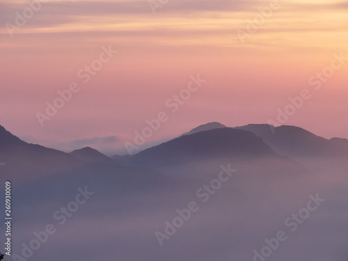 Sun set in Taiwans mountain region - Alishan mountain sun set in warm pastel colors with fog between mountain ranges © Johann