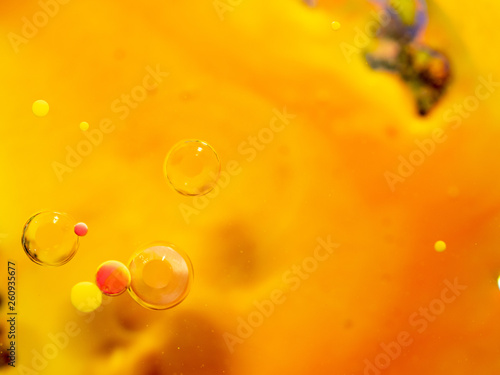 Yellow, pink and transparent spheres in abstract orange background. Close up macro shot. Blurred background. Selective soft focus. Orange abstract universe. Bubbles in space