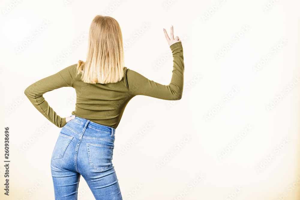 Back view of woman showing peace gesture Back view of woman showing peace gesture