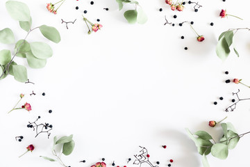 Autumn creative, modern composition. Frame made of berries, eucalyptus branches, dry roses on white background. Autumn, fall elegant concept. Flat lay, top view, copy space