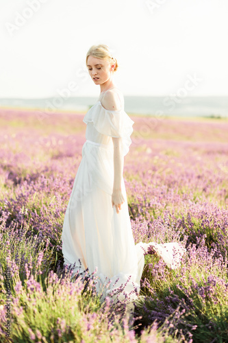 Wonderful portrait of girl in light dress in lavender field on sunset