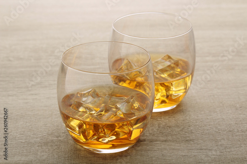 Two glasses with whiskey with ice cubes	
