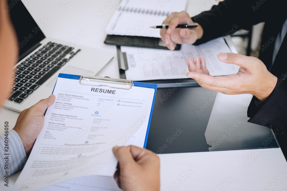 Employer or recruiter holding reading a resume during about colloquy his profile of candidate, employer in suit is conducting a job interview, manager resource employment and recruitment concept Employer or recruiter holding reading a resume during about colloquy his profile of candidate, employer in suit is conducting a job interview, manager resource employment and recruitment concept