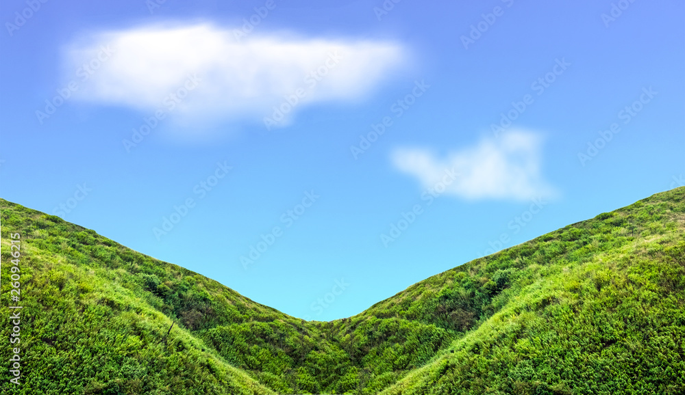 Green mountain slope with cloud in blue sky