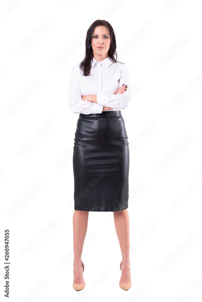 Confident successful business woman in black leather skirt with crossed arms looking at camera. Full body isolated on white background. Confident successful business woman in black leather skirt with crossed arms looking at camera. Full body isolated on white background.
